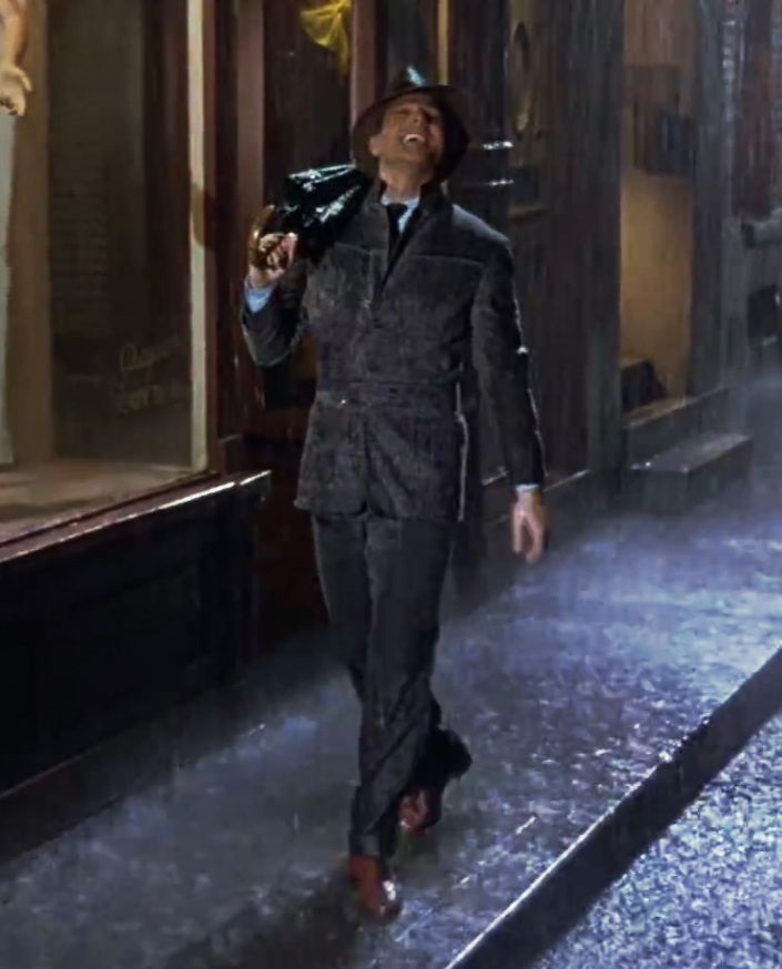 Gene Kelly tanzt mit einem Regenschirm durch den Regen in Singin’ in the Rain